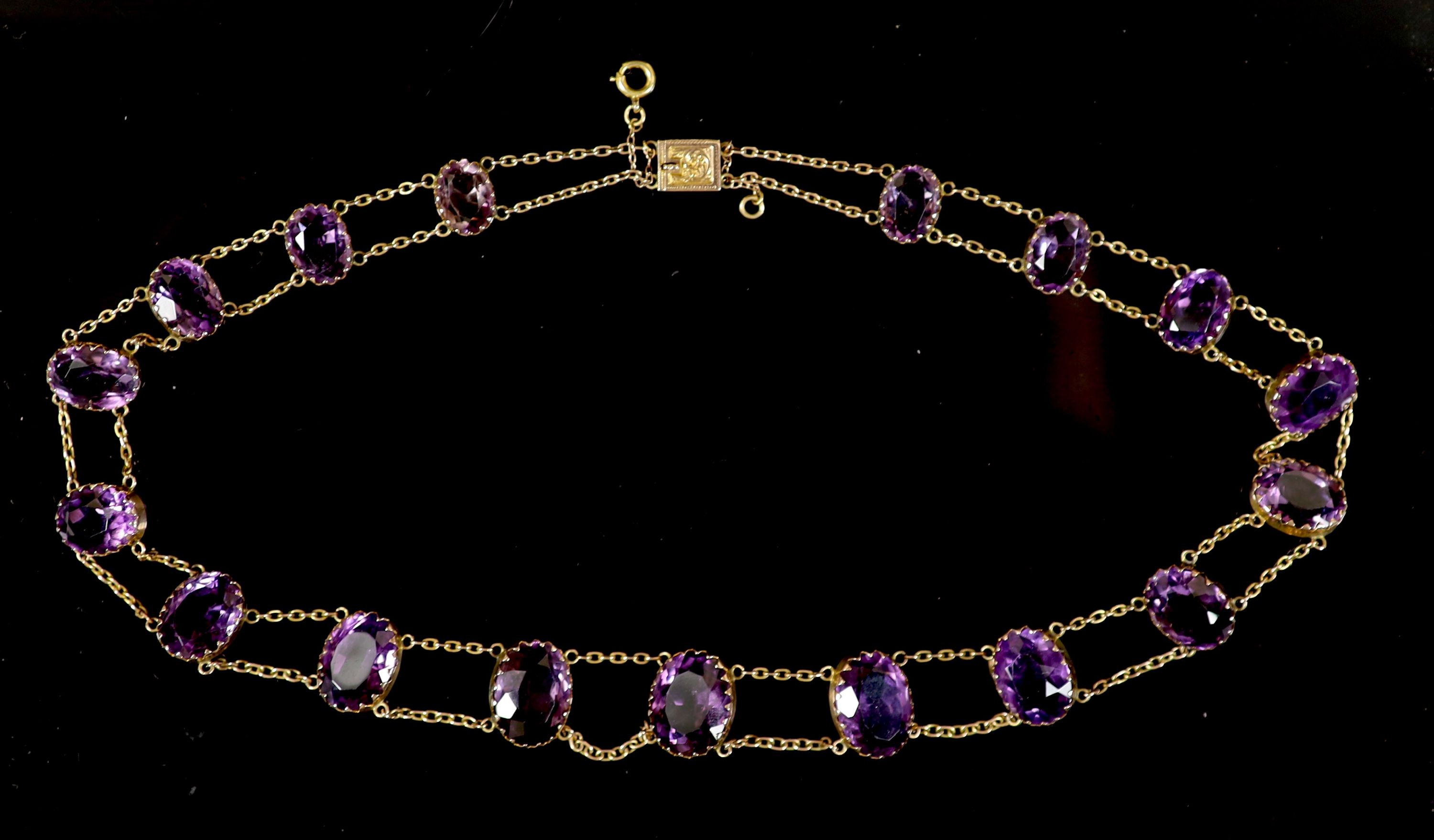 An Edwardian 9ct gold and graduated oval cut amethyst riviere necklace